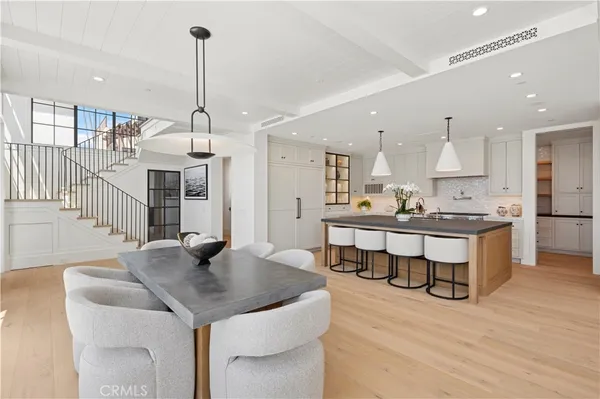 a kitchen with stainless steel appliances kitchen island granite countertop a table chairs sink and cabinets