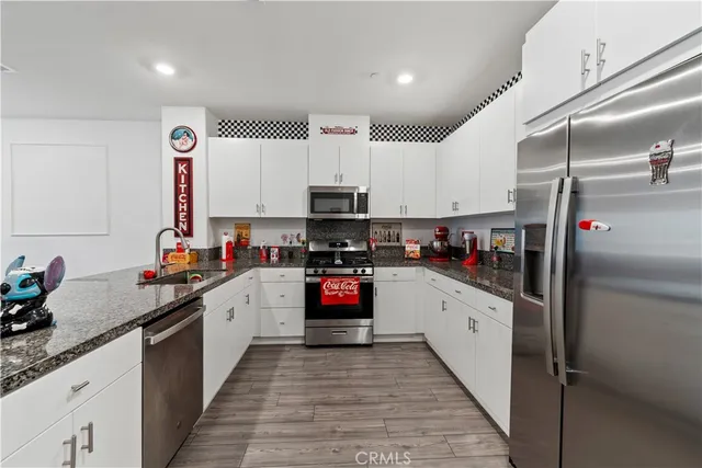 a kitchen with stainless steel appliances granite countertop a refrigerator and a sink