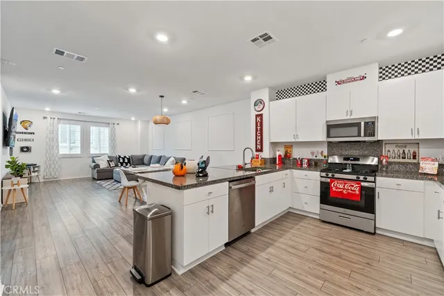 a kitchen with counter top space a sink cabinets and wooden floor