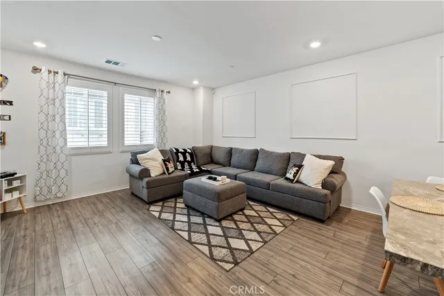a living room with furniture a wooden floor and a window