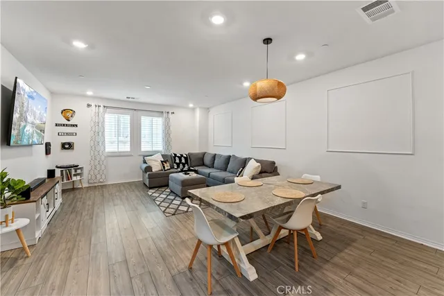 a living room with furniture a flat screen tv and a wooden floor