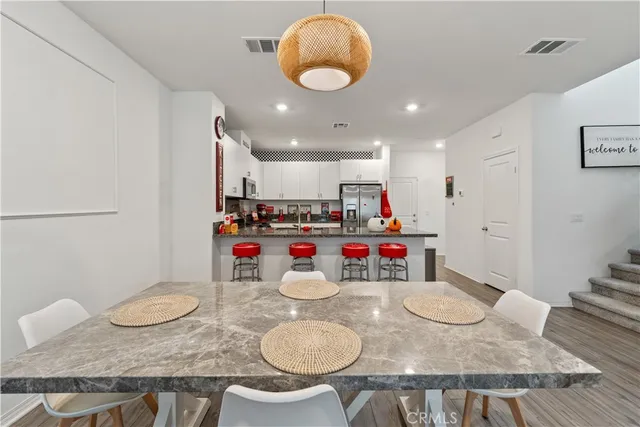 a kitchen with sink a dining table and chairs