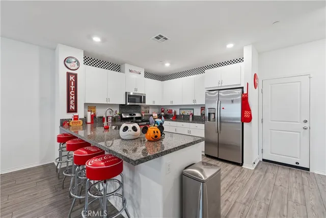 a kitchen with stainless steel appliances granite countertop a sink refrigerator and cabinets