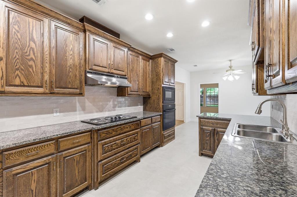 19 Timbergreen Circle Denton, TX 76205 - Photo 14 of 40 a kitchen with stainless steel appliances granite countertop a stove a sink and a microwave