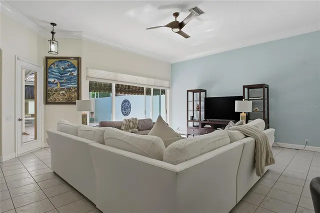 a living room with furniture a ceiling fan and a window