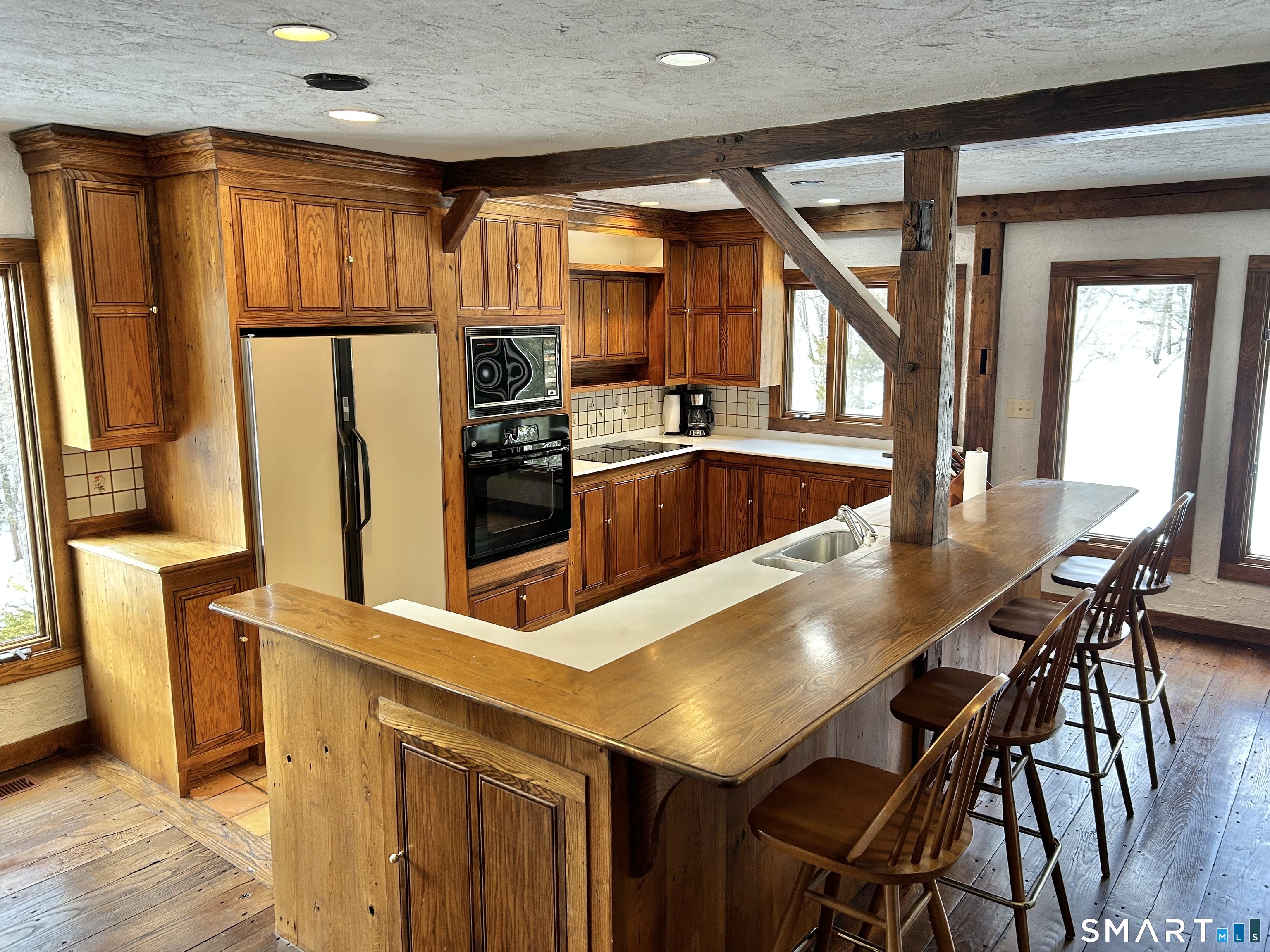 148 Flanders Road Woodbury, CT 06798 - Photo 2 of 16 a kitchen with stainless steel appliances granite countertop a refrigerator a stove and white cabinets with wooden floor