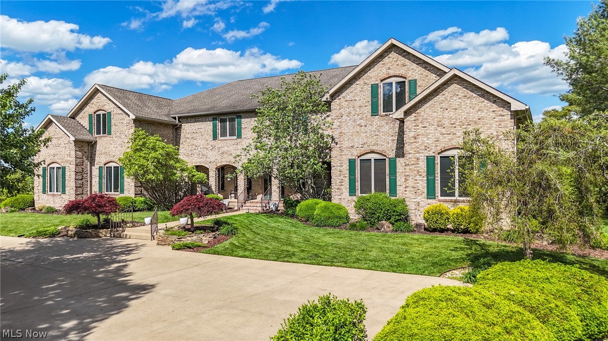 1602 Glendale Road, Unit 3 Marietta, OH 45750 - Photo 1 of 49 Stone facade residence featuring a multi-gabled roofline, arched entryways, green window shutters, a paved driveway, and meticulously landscaped grounds