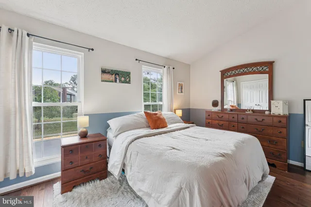 a bedroom with a bed and a dresser next to a window