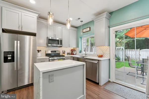 a kitchen with a sink a refrigerator a window and cabinets