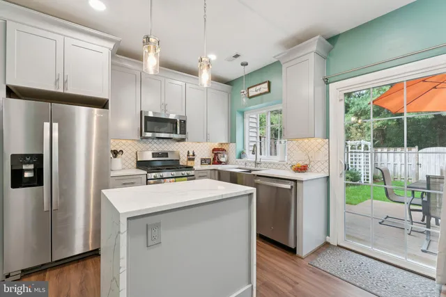 a kitchen with a sink a refrigerator a window and cabinets