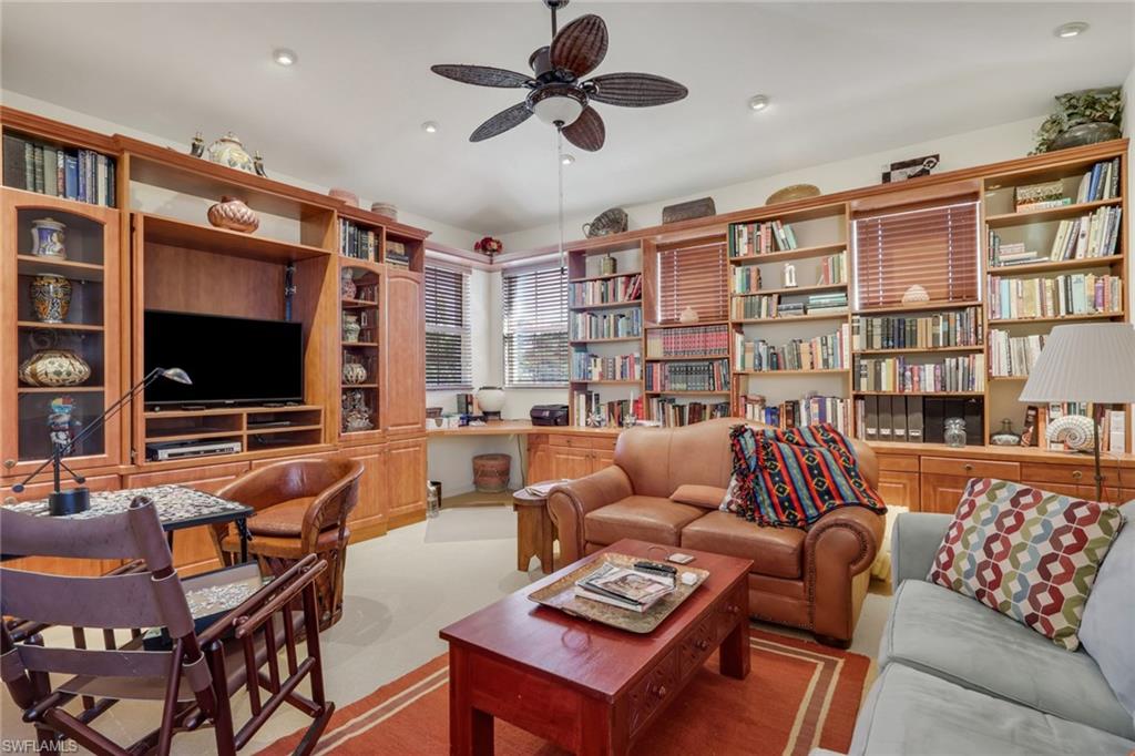 10801 Crooked River Road, Unit 203 Estero, FL 34135 - Photo 15 of 27 a living room with furniture a flat screen tv and a bookshelf