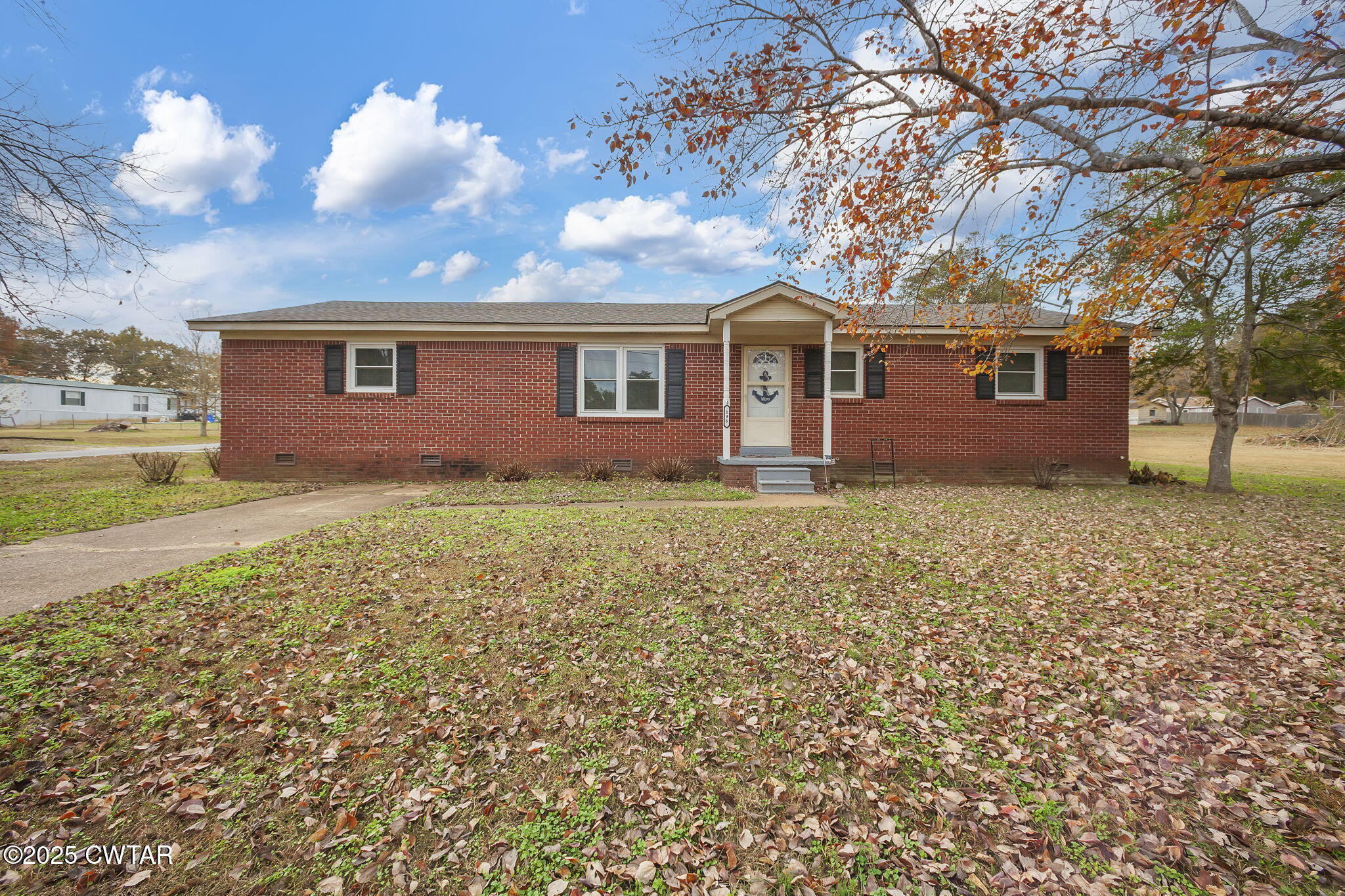 a front view of house with yard and trees