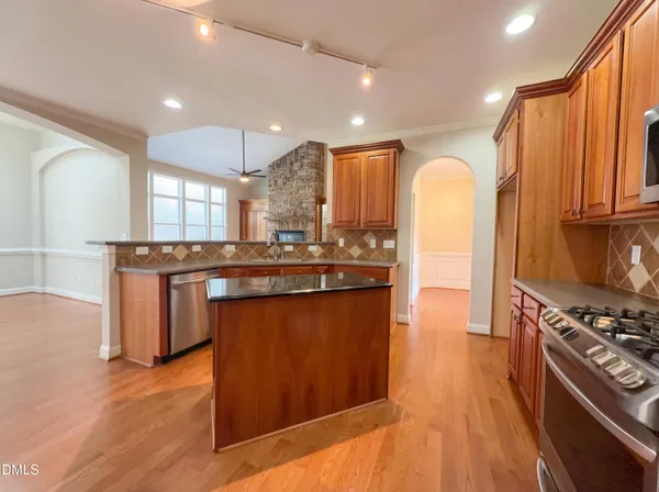 a kitchen with stainless steel appliances granite countertop a stove a sink and a refrigerator