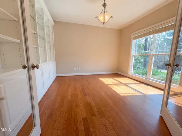 a view of empty room with wooden floor and fan
