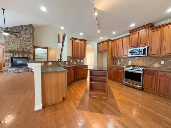 a large kitchen with stainless steel appliances granite countertop a stove granite counter tops and white cabinets