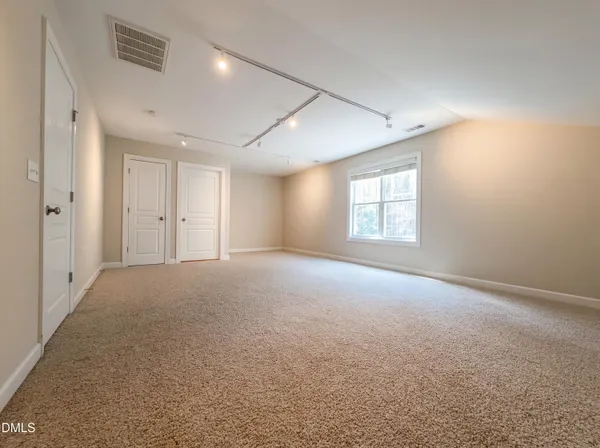 a view of a big room with windows and chandelier fan