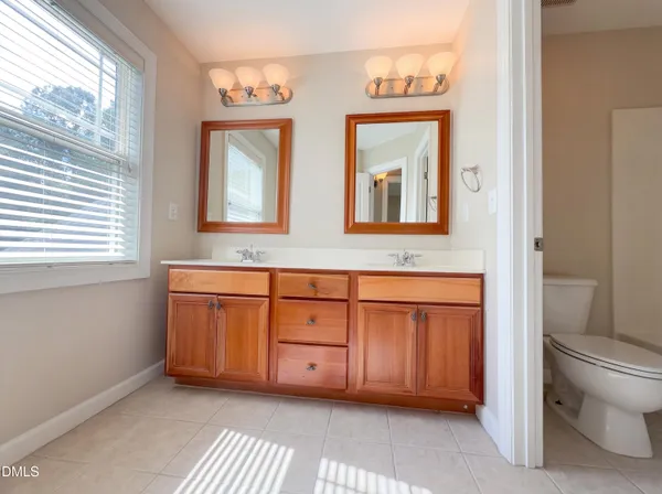 a bathroom with a granite countertop sink mirror and a toilet