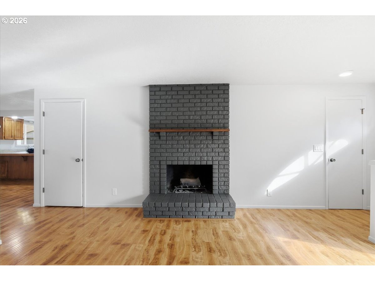 545 Baldwin Avenue Northeast Salem, OR 97301 - Photo 7 of 29 a view of an empty room with wooden floor and a fireplace