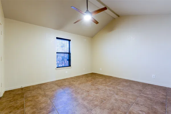 an empty room with closet and fan