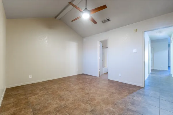 an empty room with a ceiling fan and windows