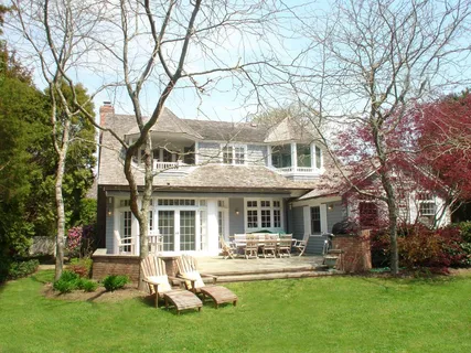 a front view of a house with yard and green space