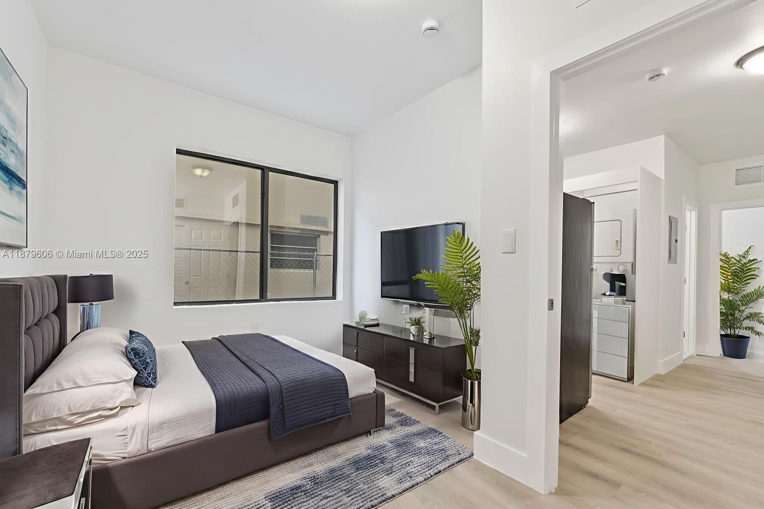 858 Northwest 3rd Street, Unit 112 Miami, FL 33128 - Photo 3 of 15 a bedroom with a bed and a flat screen tv