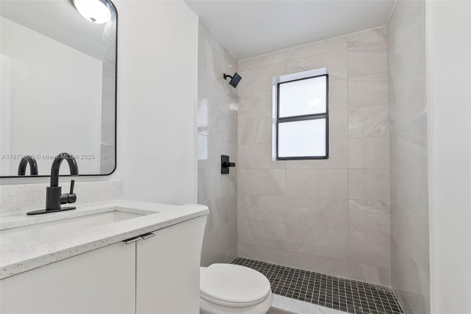858 Northwest 3rd Street, Unit 112 Miami, FL 33128 - Photo 5 of 15 a bathroom with a sink a toilet and shower