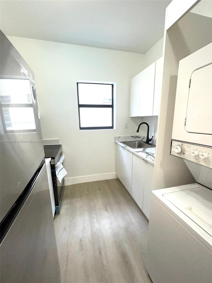 858 Northwest 3rd Street, Unit 112 Miami, FL 33128 - Photo 7 of 15 a kitchen with sink and refrigerator