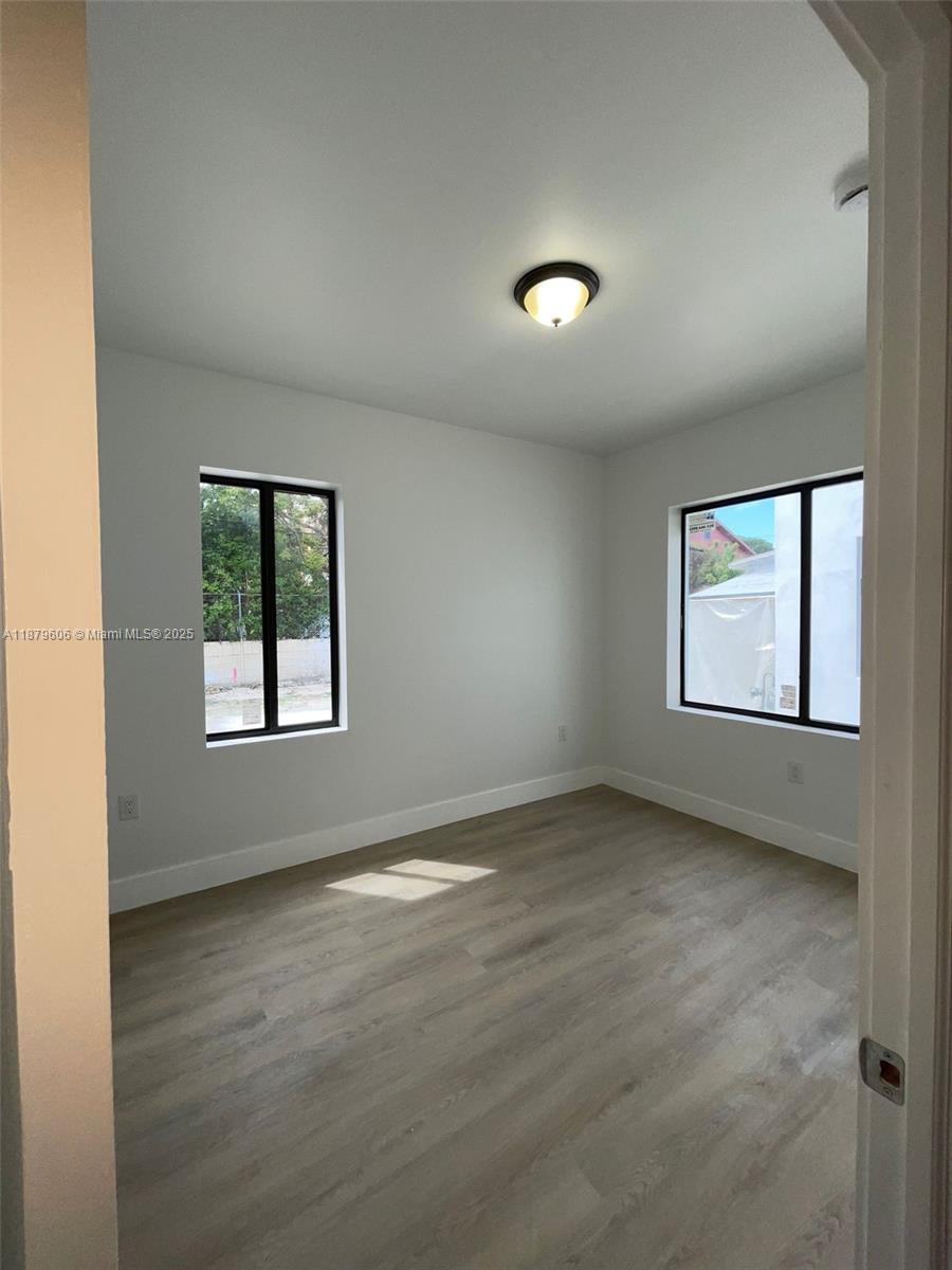 858 Northwest 3rd Street, Unit 112 Miami, FL 33128 - Photo 9 of 15 an empty room with windows