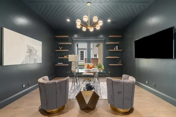 a room with furniture a chandelier and a flat screen tv