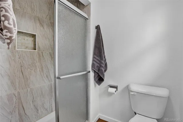 a bathroom with a toilet and a shower