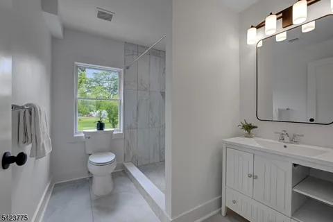 a bathroom with a sink toilet a mirror and shower