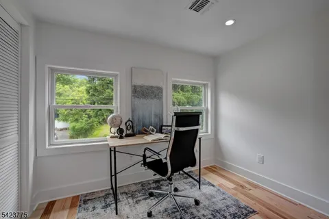 a view of a workspace with furniture and a window