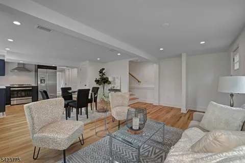 a living room with furniture and a dining table with kitchen view