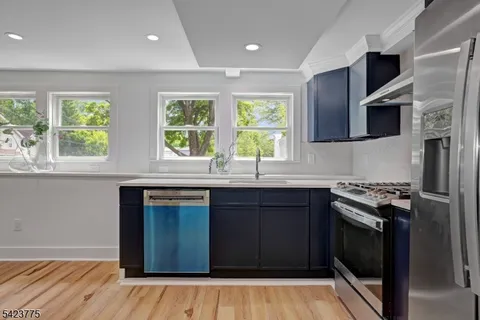 a kitchen with stainless steel appliances wooden cabinets and a stove top oven