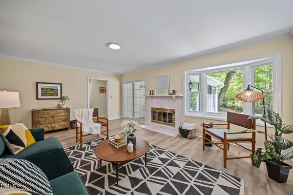 a living room with furniture a fireplace and a floor to ceiling window