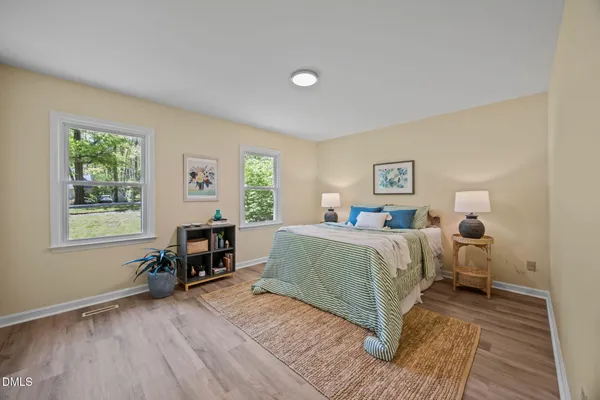 a spacious bedroom with a bed a table and a window