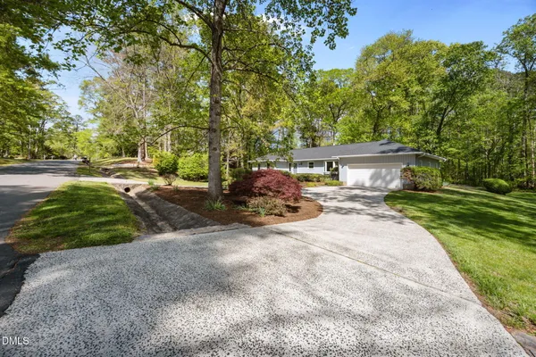 a front view of a house with a yard and trees