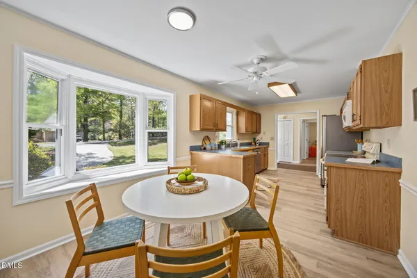 a kitchen with a dining table chairs and window