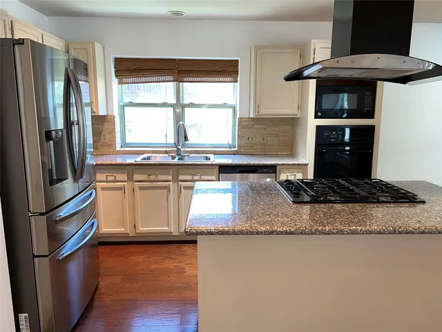 a kitchen with stainless steel appliances granite countertop a stove a refrigerator and a sink