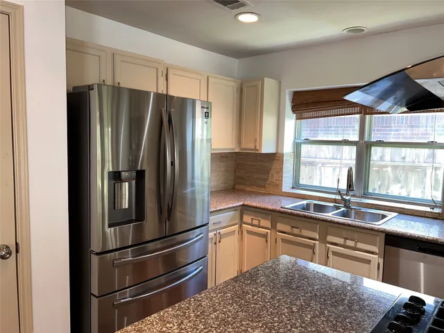 a kitchen with stainless steel appliances granite countertop a refrigerator and a sink