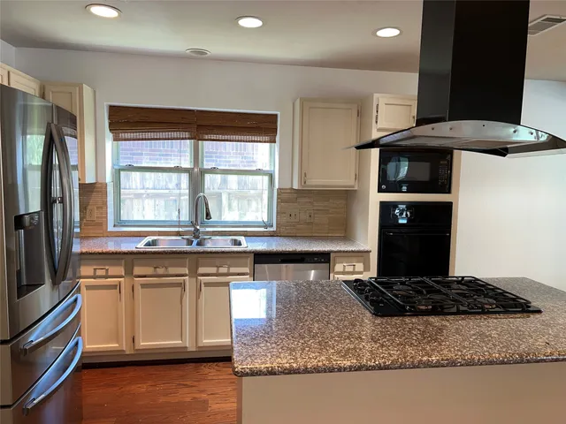 a kitchen with stainless steel appliances granite countertop a stove a sink and a microwave