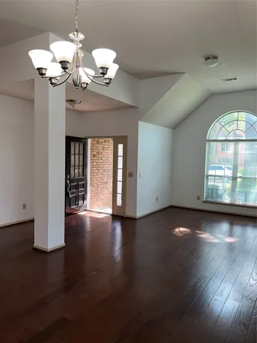 a view of a room with wooden flooring and chandelier