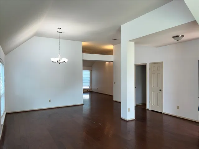 an empty room with wooden floor and bathroom