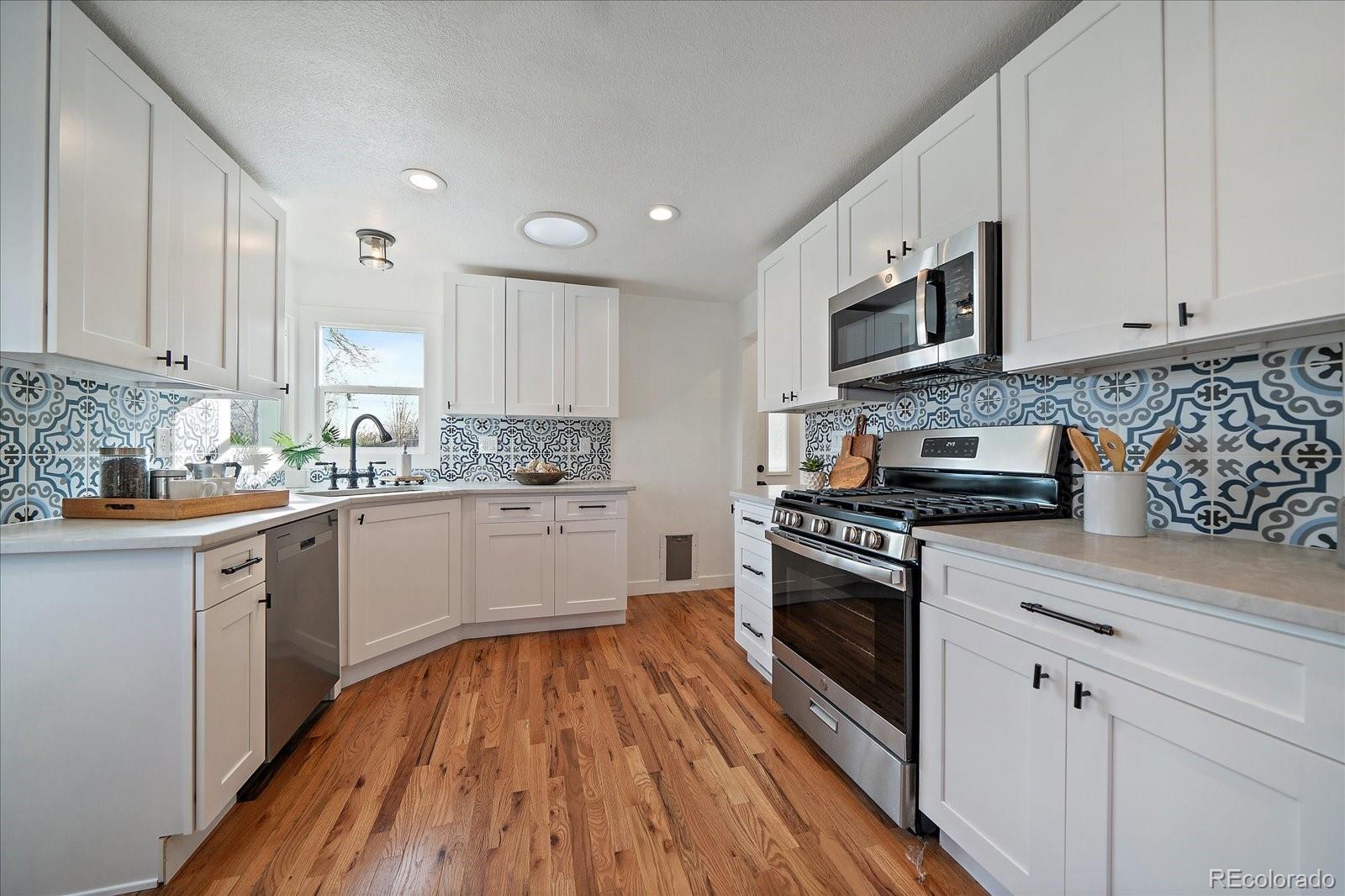 9200 Grandview Avenue Arvada, CO 80002 - Photo 14 of 45 a kitchen with stainless steel appliances granite countertop a stove a sink and a microwave