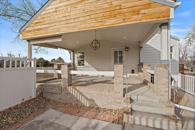 a view of a patio with table and chairs with wooden floor and fence