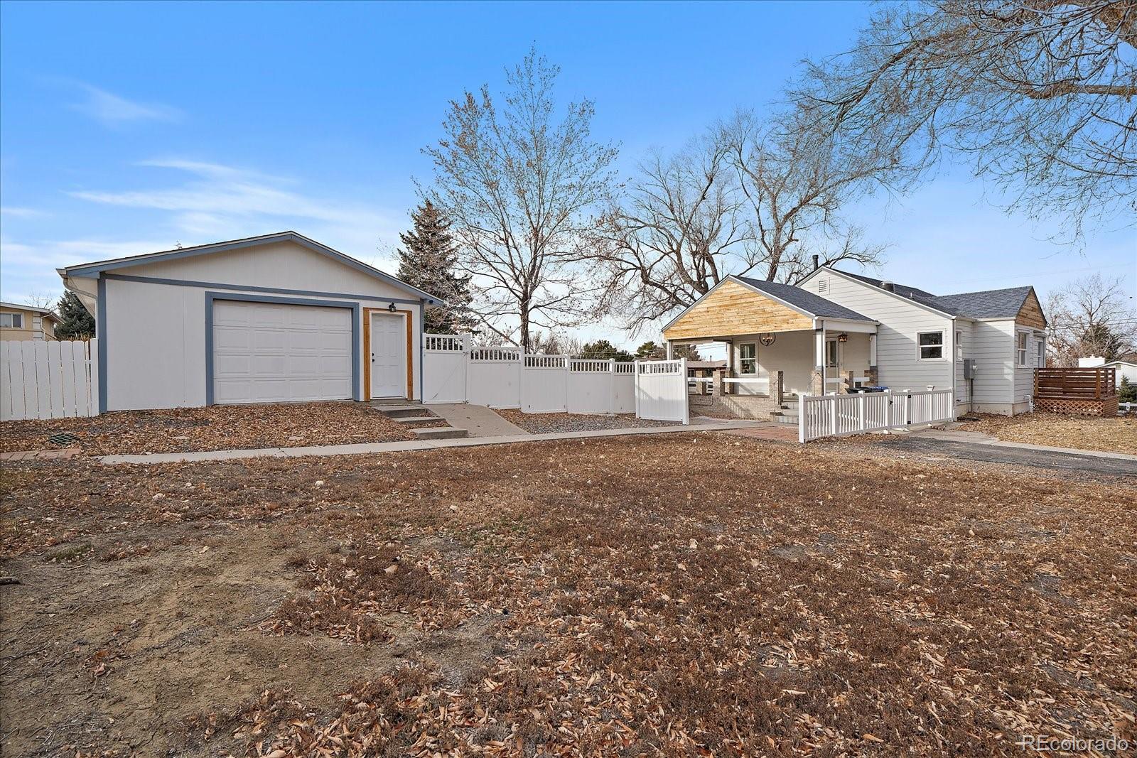 9200 Grandview Avenue Arvada, CO 80002 - Photo 34 of 45 a backyard of a house with table and chairs under an umbrella