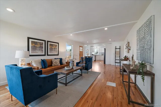 a living room with furniture wooden floor and a lamp