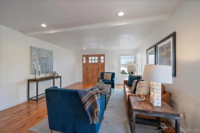 a living room with furniture and a wooden floor