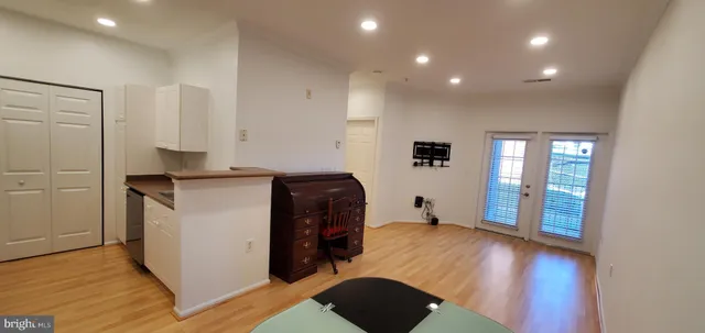 a view of a hallway with wooden floor and furniture